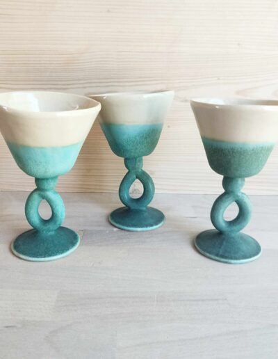 Photographie de trois verres à vin crème et turquoise