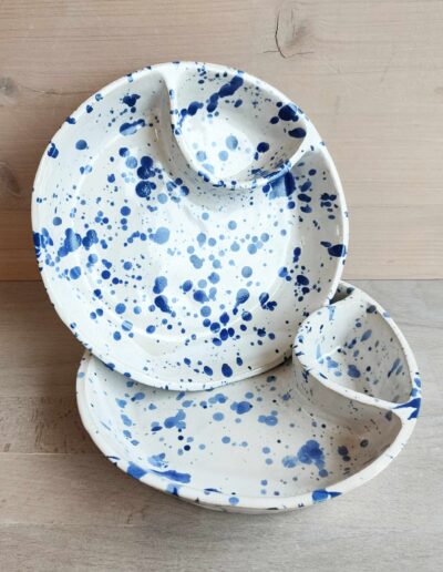 Photographie de deux assiettes blanches et tachetées bleu avec un compartiment pour la sauce.