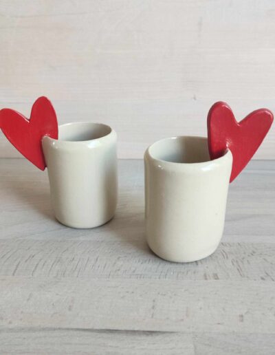 Photographie de deux tasses à expresso dont les anses sont des cœurs rouges